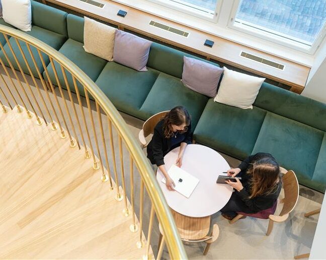 Spiraltrappa med två personer som sitter vid bord nedanför