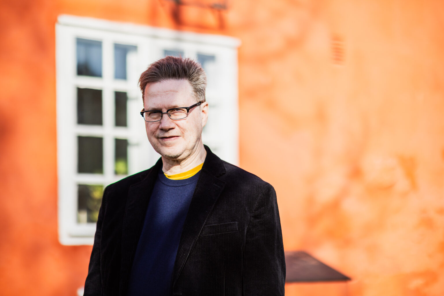 person utanför en röd byggnad