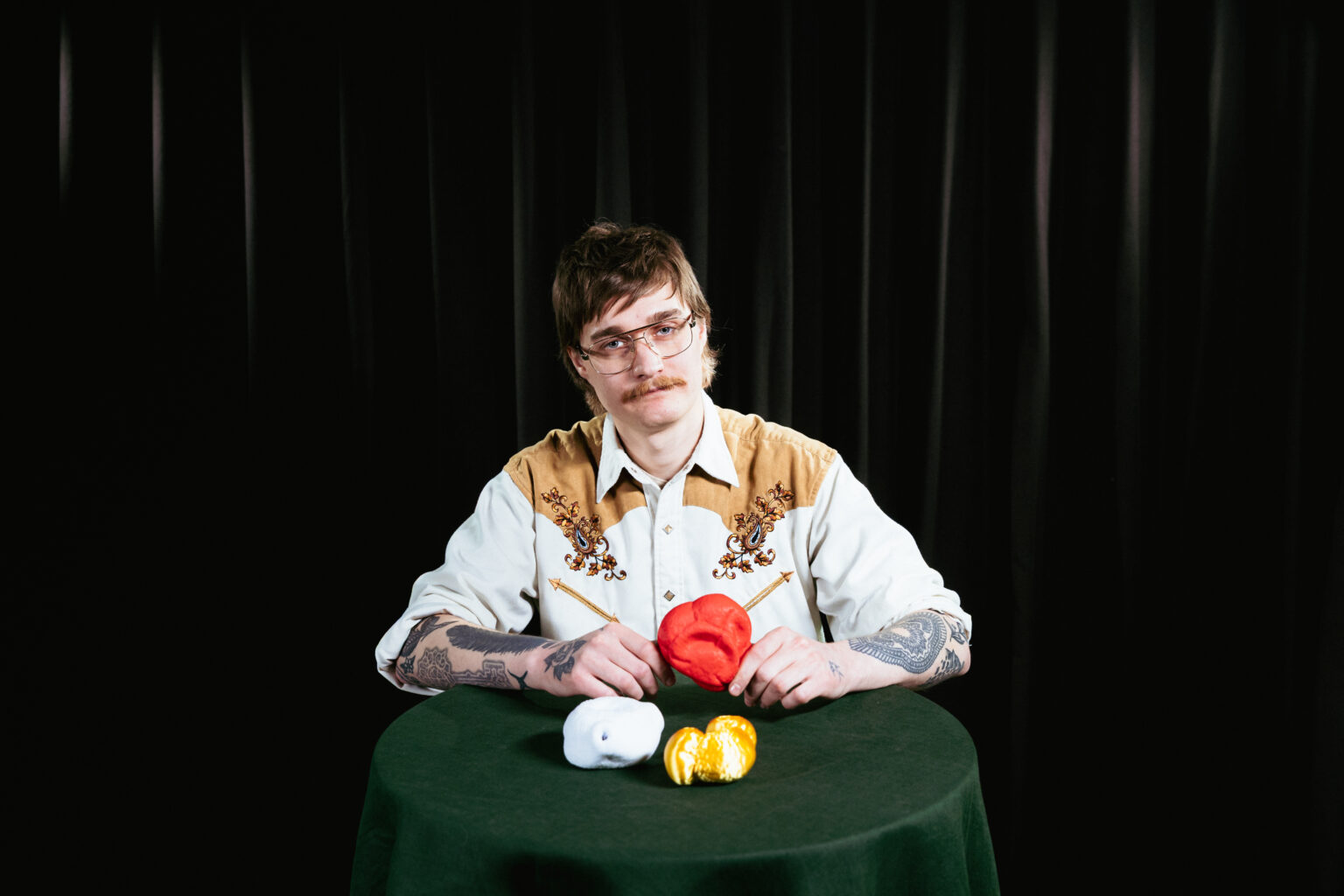 man sitter bakom ett bord med miniatyrer av pollenkorn framför sig