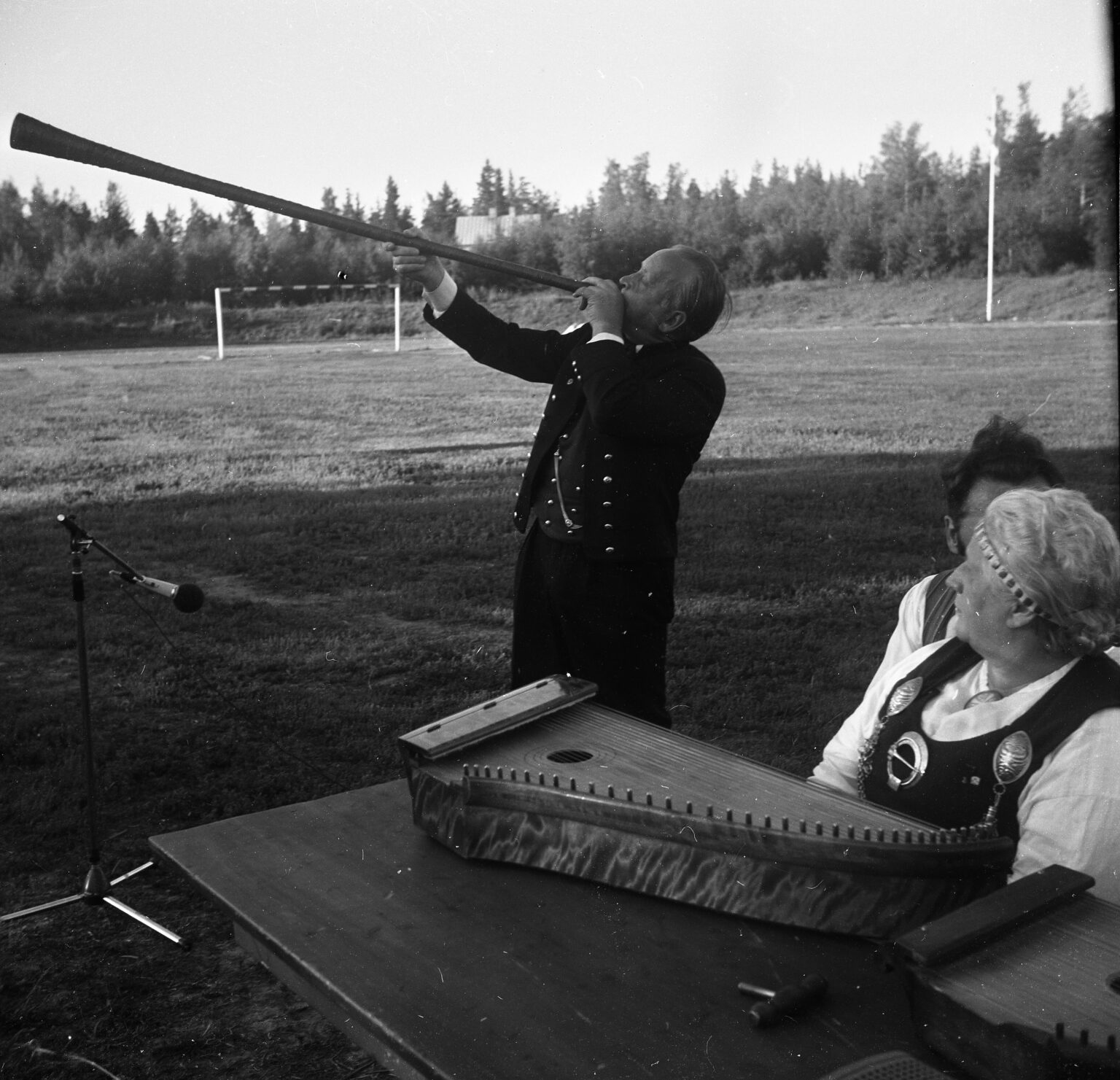 Man blåser i gammaldags näverlur.